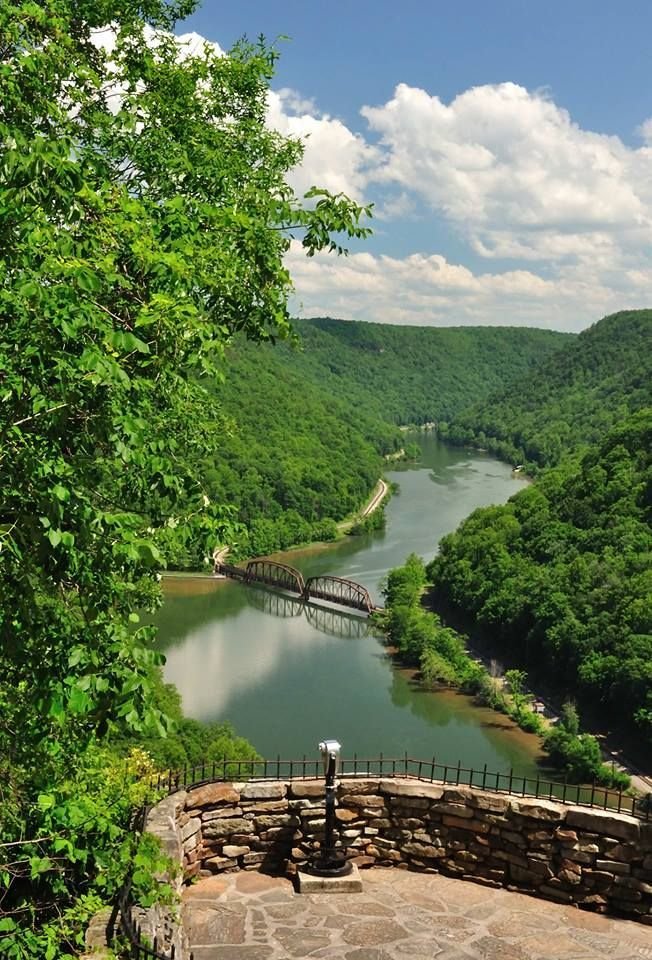 This may contain: a scenic view of a river surrounded by trees