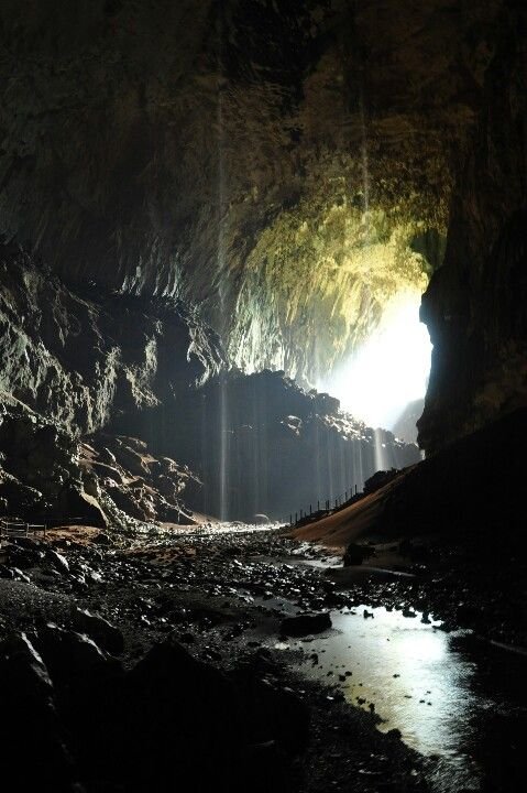 This may contain: the light at the end of the tunnel shines brightly in the dark, with water running through it