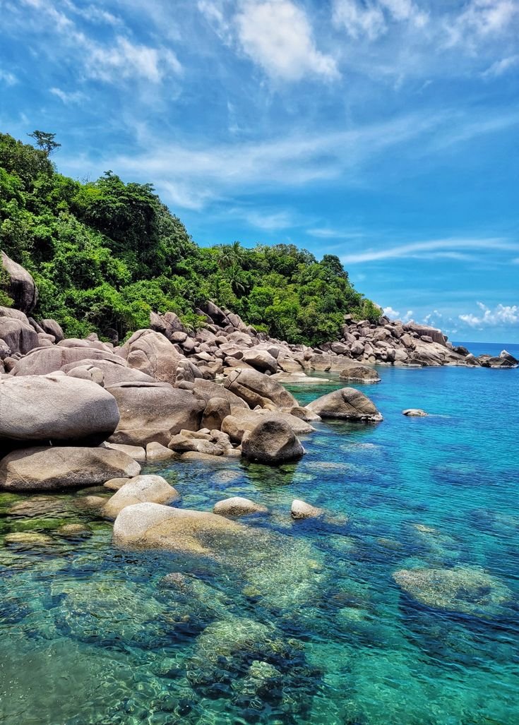 This may contain: the water is crystal blue and clear with rocks in it's bottom right hand corner