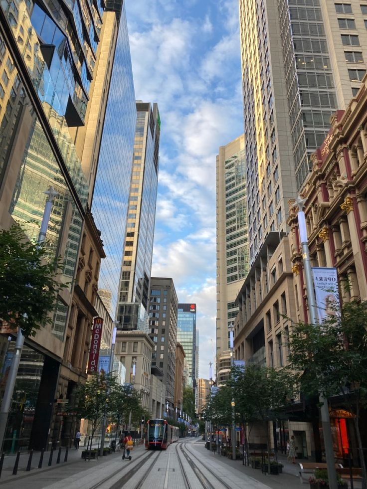 This may contain: an empty city street with tall buildings in the background