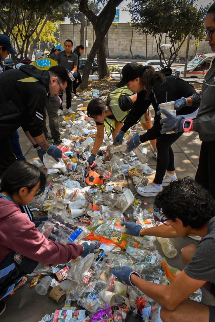 This may contain: people picking up plastic bottles on the street