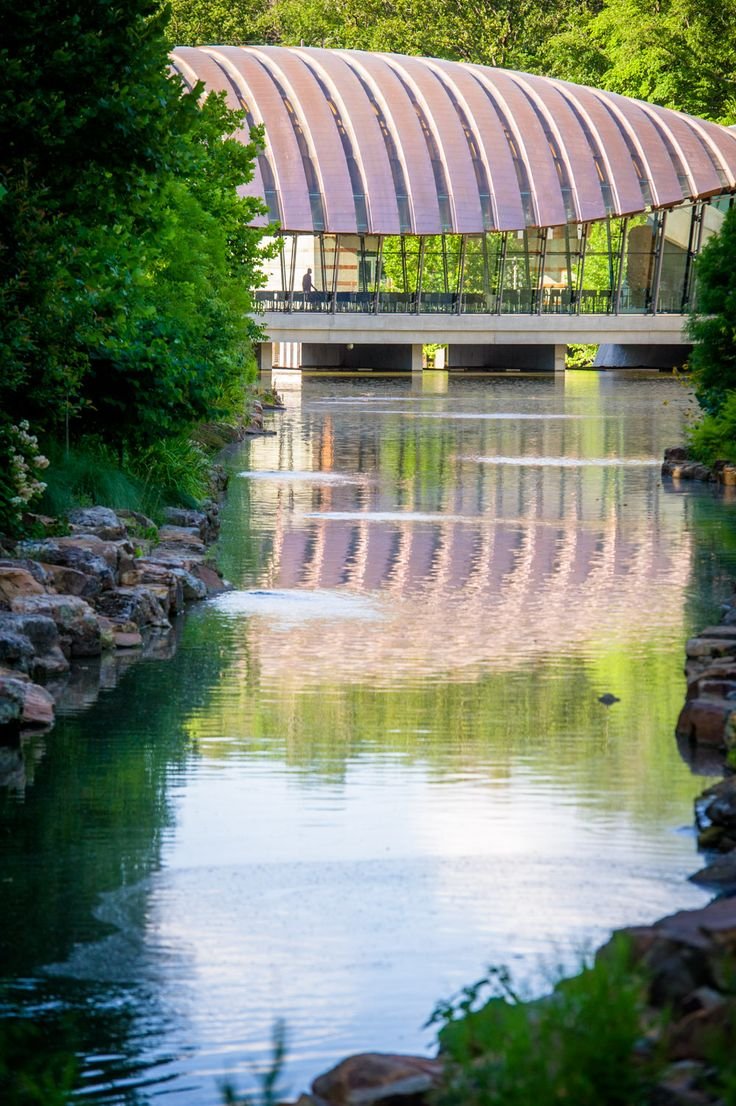 This may contain: a bridge over a river next to trees and rocks