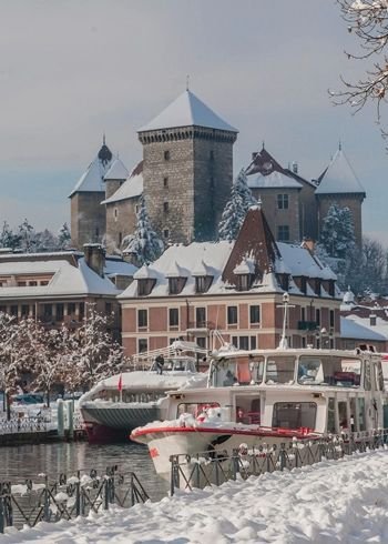 This may contain: a boat is parked in the snow near some buildings and water with lots of snow on it