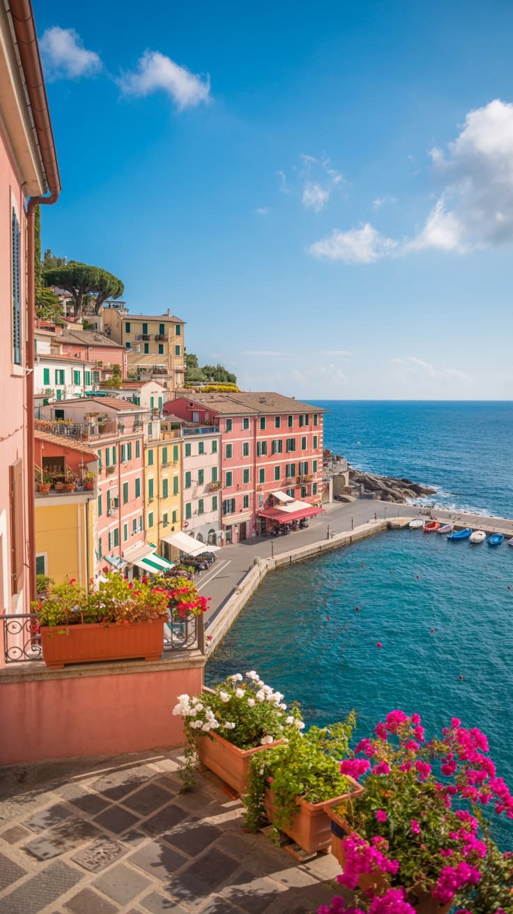 This may contain: colorful buildings on the shore line with boats in the water and flowers growing out of pots