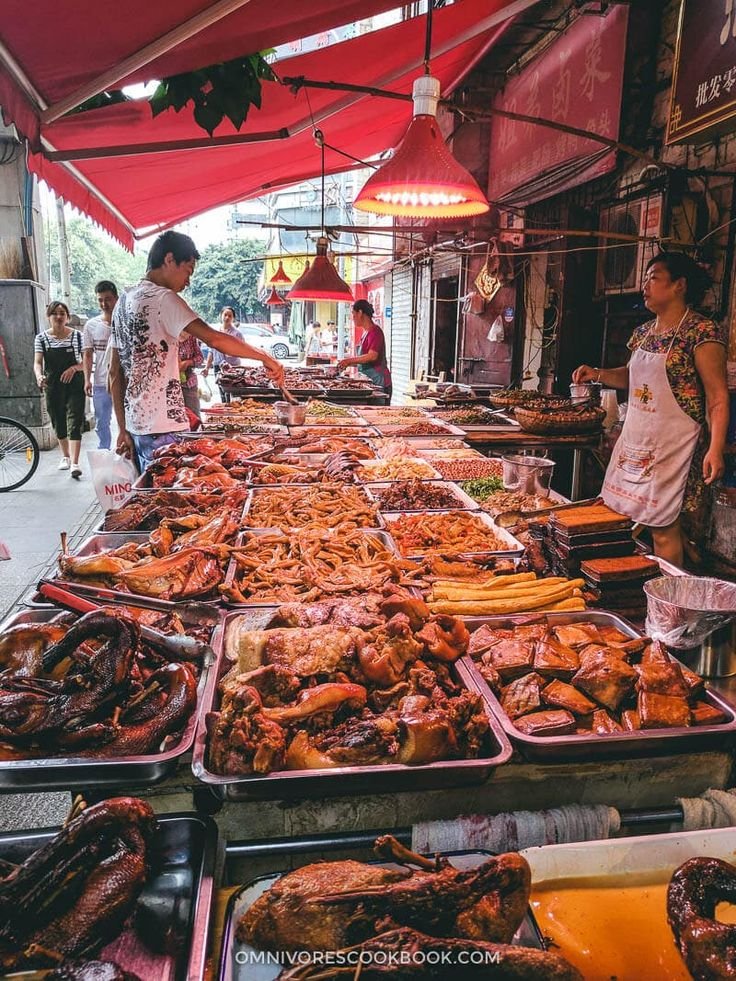 This may contain: an outdoor market with many trays of food