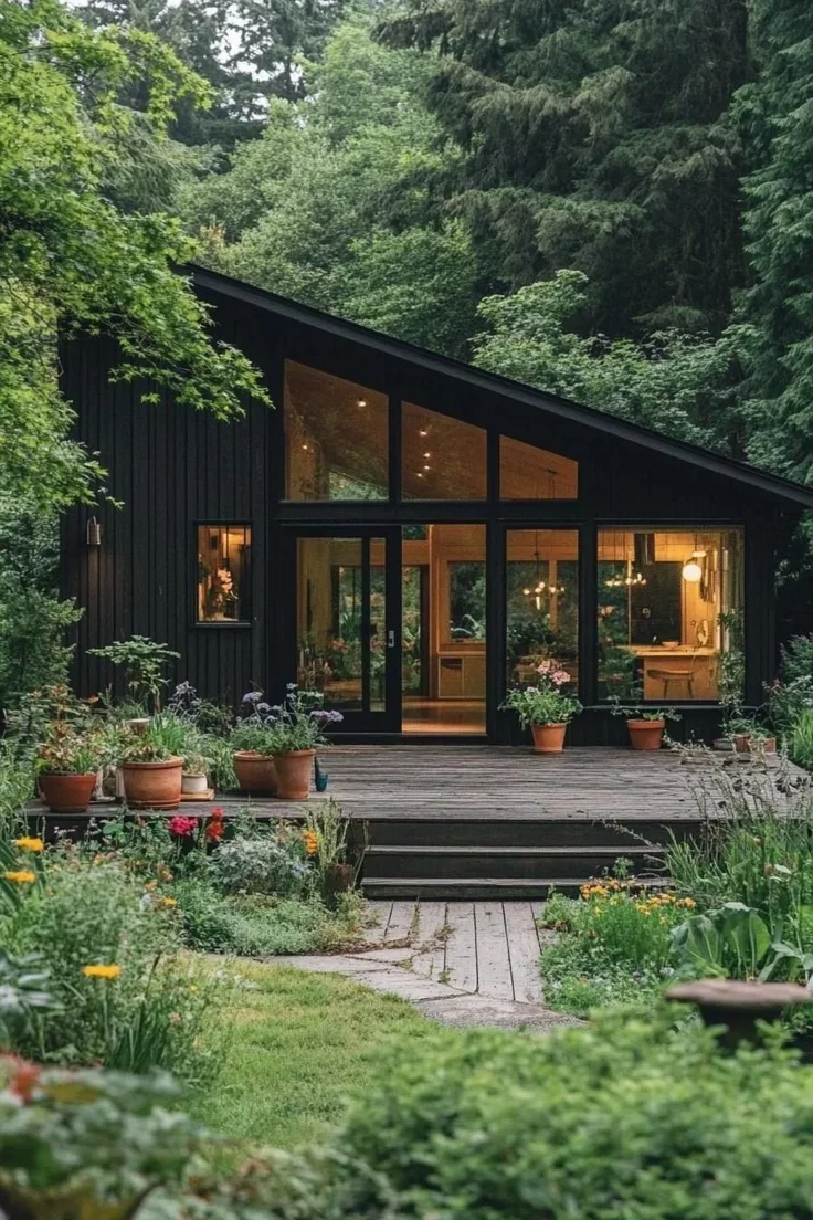 This may contain: a black house surrounded by greenery and trees