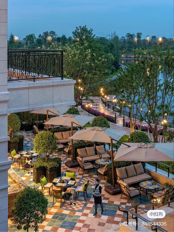 This may contain: an outdoor seating area with tables and umbrellas