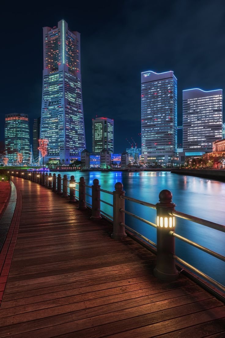 This may contain: the city skyline is lit up at night