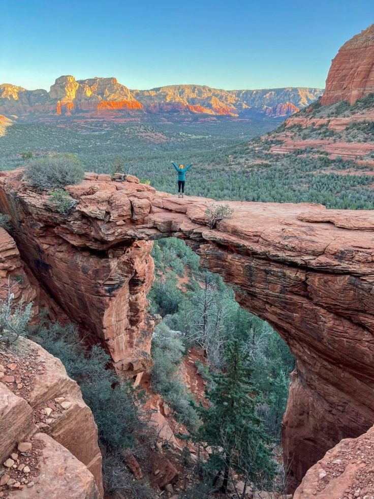 This may contain: a man standing on the edge of a cliff