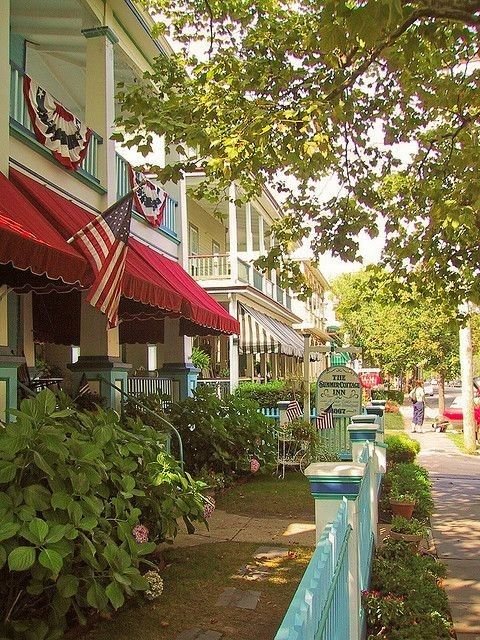 This may contain: a row of buildings with red, white and blue awnings