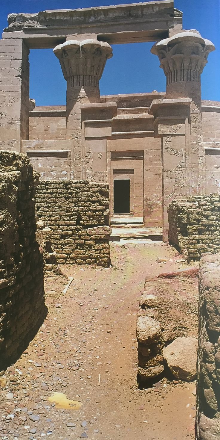 This may contain: the entrance to an ancient building with two large stone pillars on each side and one small door at the end