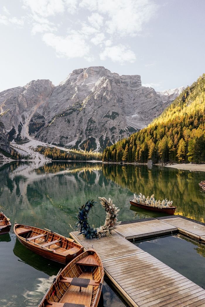 This may contain: there are many boats that are docked on the water by the dock and mountains in the background