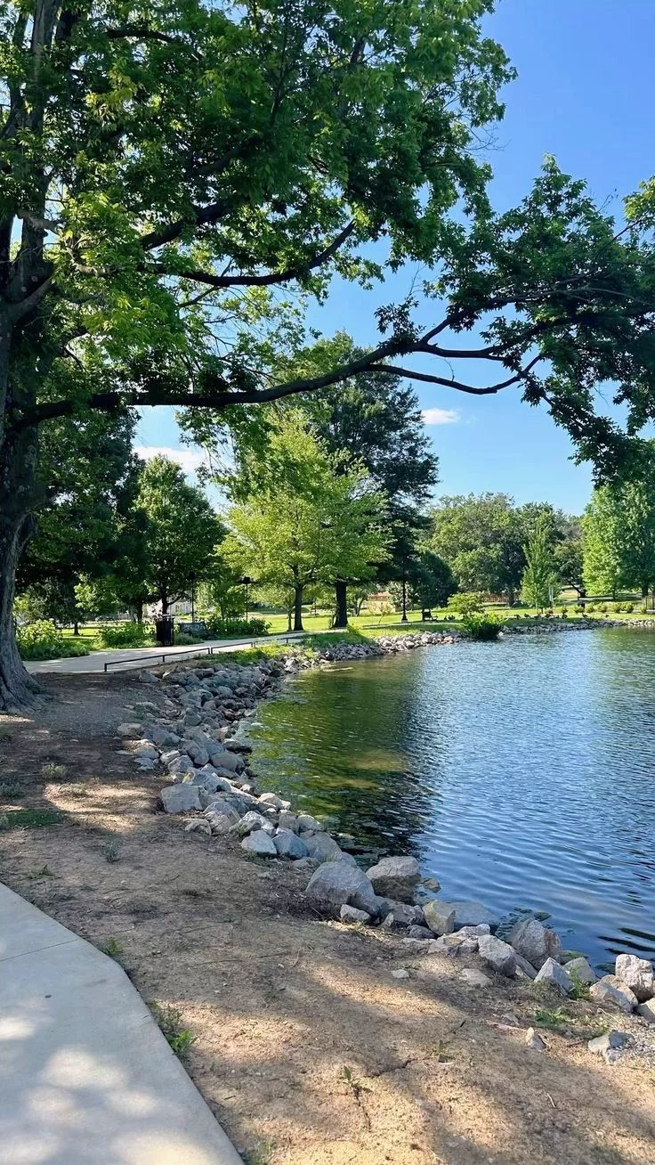 This may contain: there is a small lake in the park
