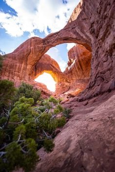 This may contain: an arch shaped rock formation in the desert