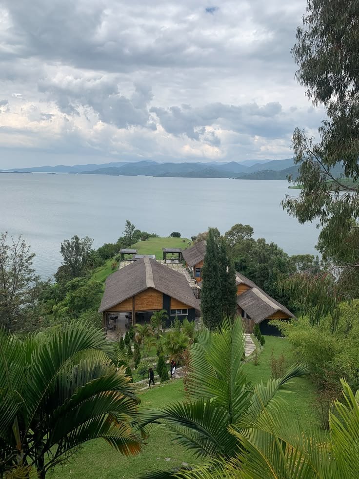 This may contain: an aerial view of a house with trees and water in the background
