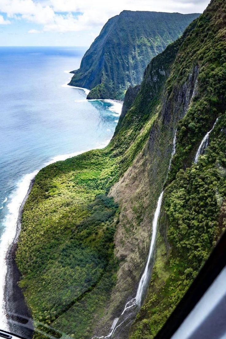 This may contain: the view from inside an airplane looking down at a waterfall in the middle of the ocean