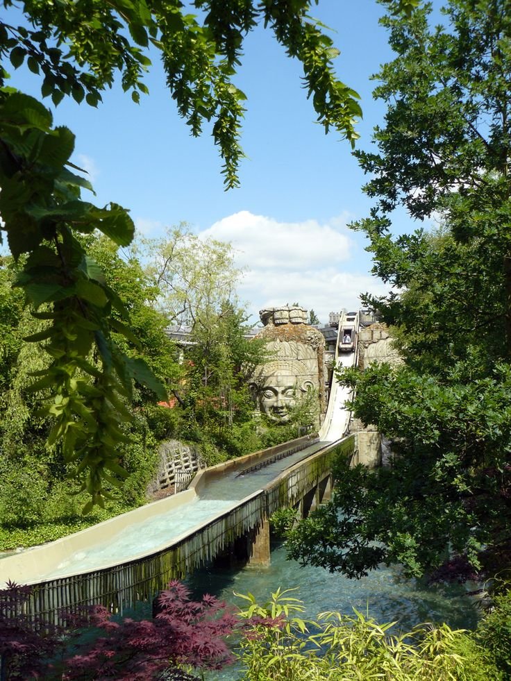 This may contain: a bridge that has a face on it and some trees in front of the bridge