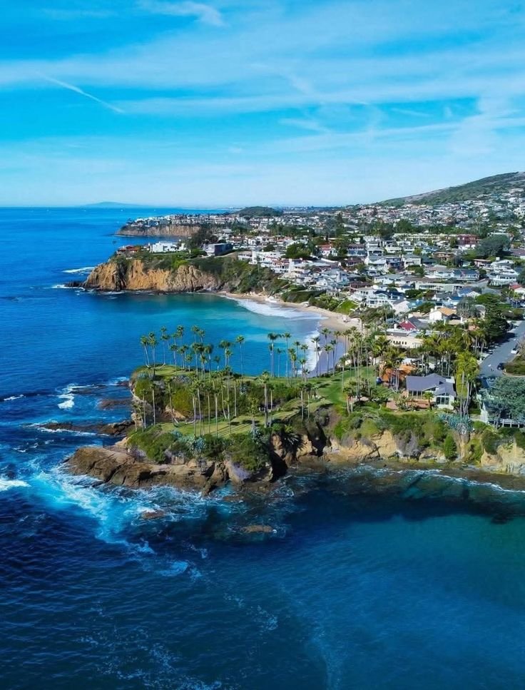 This may contain: an aerial view of the ocean and coastline with houses on land in the foreground