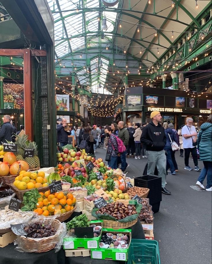 This may contain: an outdoor market with lots of fruits and vegetables