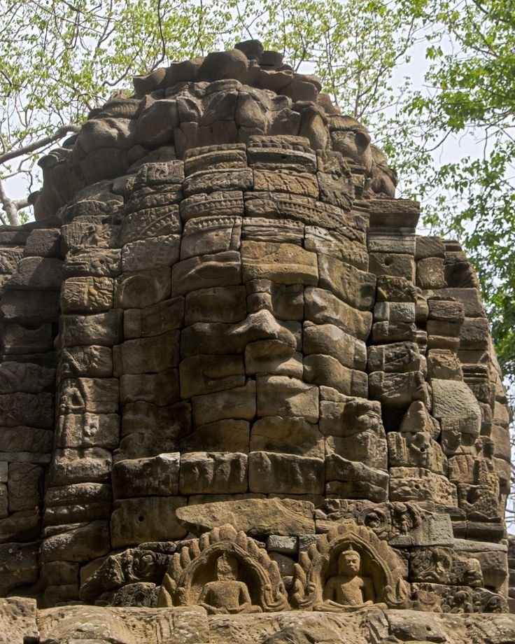 This may contain: an intricately carved stone face on the side of a building