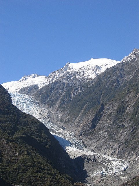 This may contain: the mountains are covered in snow and ice