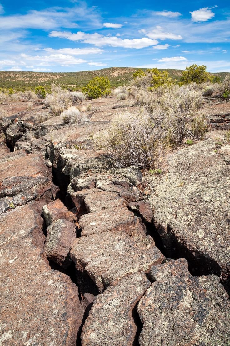 This may contain: the rocks are very large and have little vegetation growing out of them in the desert