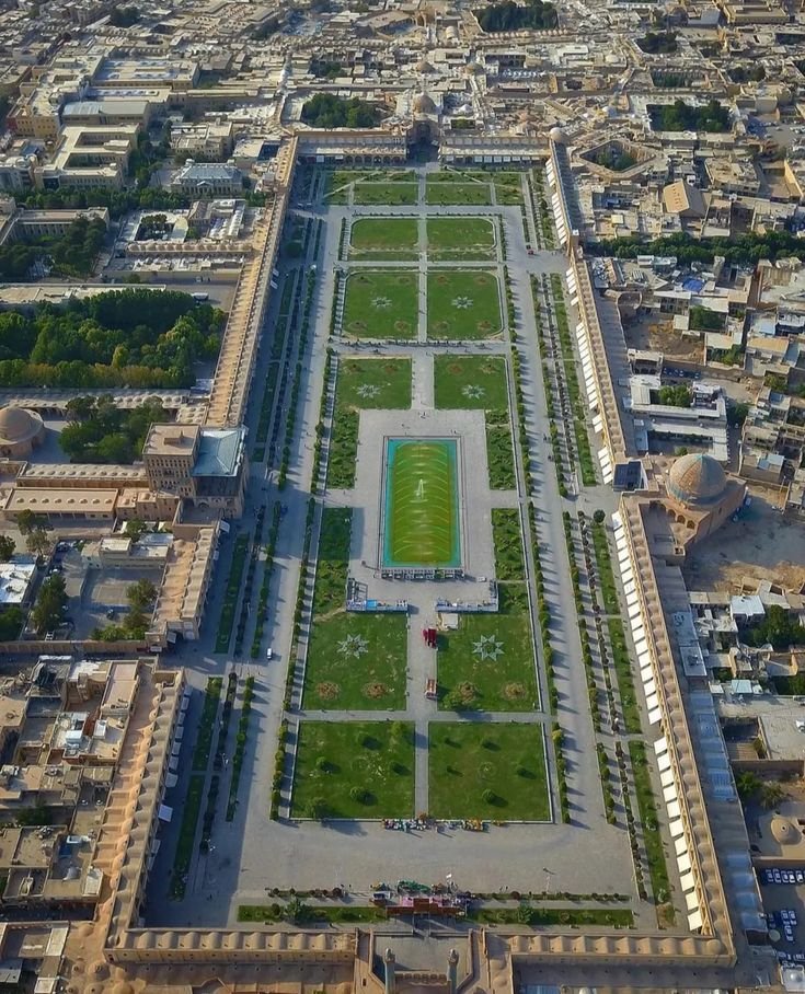 This may contain: an aerial view of a large grassy field in the middle of a city with lots of tall buildings