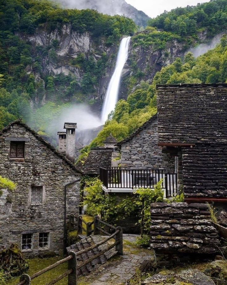 This may contain: an old stone building with a waterfall in the background