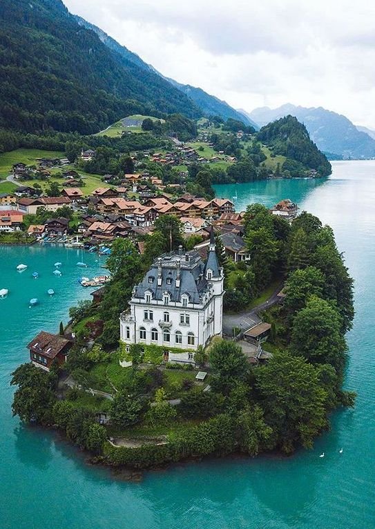 This may contain: an island in the middle of water with houses on it and boats floating near by