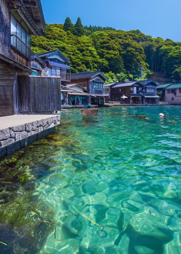 This may contain: the water is crystal blue and clear with houses in the backgrouds on either side