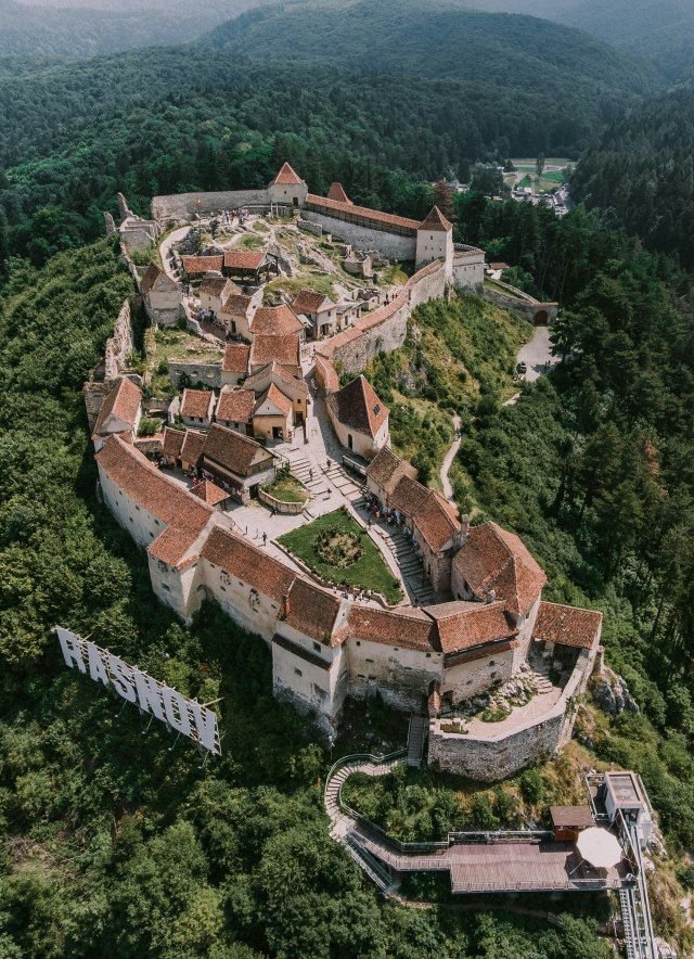 This may contain: an aerial view of a castle surrounded by trees