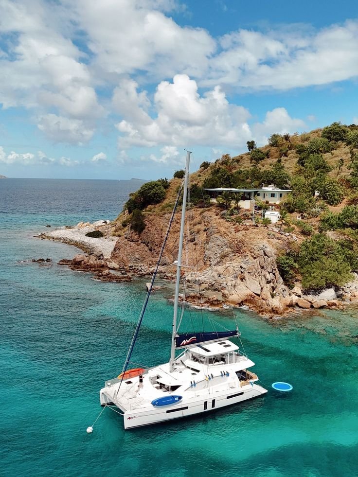 This may contain: a catamaran sailing in the blue water near an island