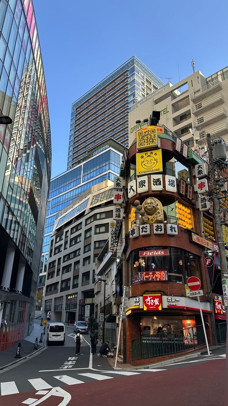 This may contain: a very tall building with lots of signs on it's side in the city