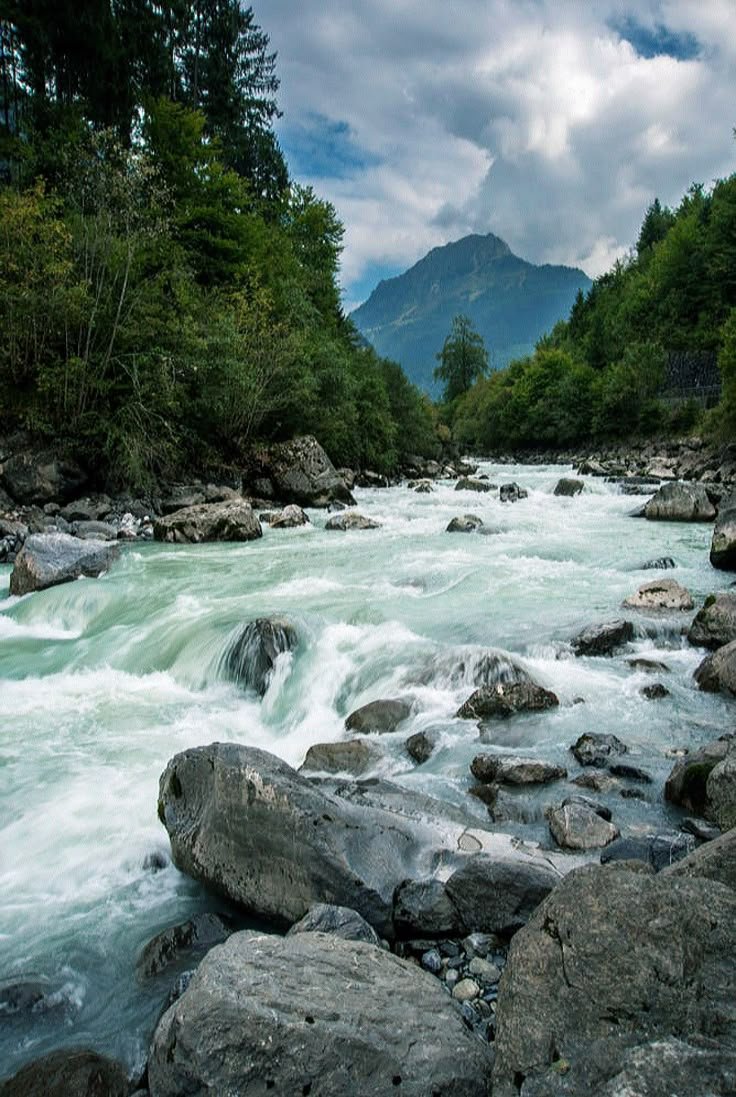 This may contain: a river with rocks and water running through it