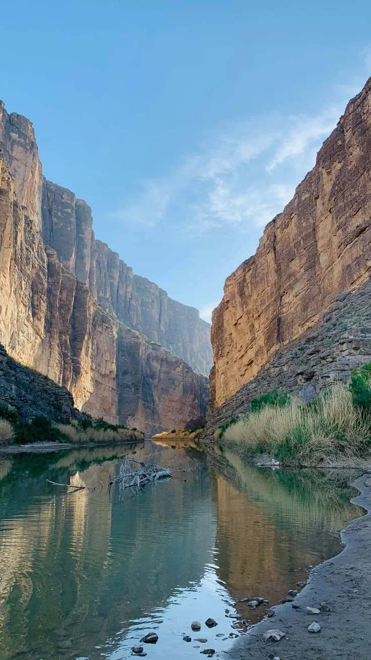 This may contain: a river running through a canyon surrounded by mountains