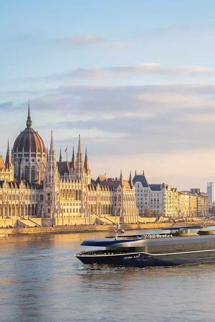 This may contain: a large boat floating on top of a river next to a tall building