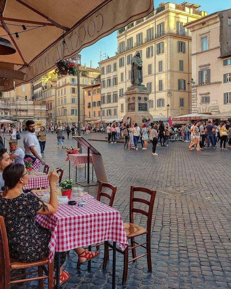 This may contain: people sitting at tables in an outdoor cafe