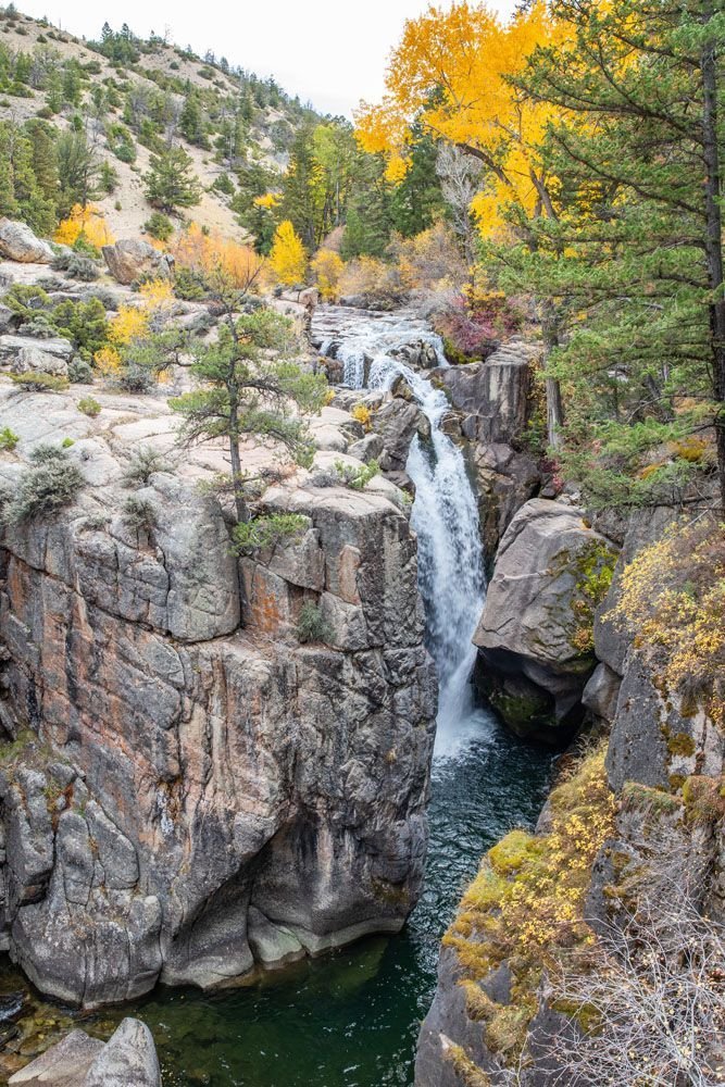 This may contain: a small waterfall in the middle of a canyon