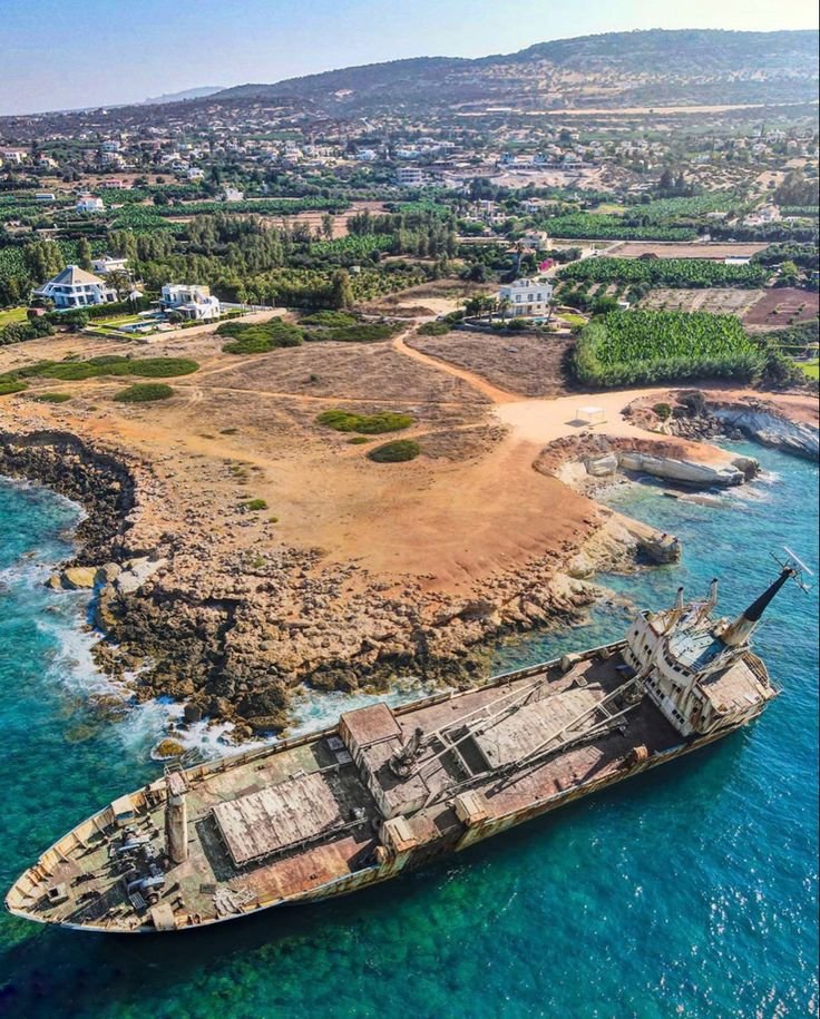 This may contain: an old ship is in the middle of the ocean near a small island with houses on it