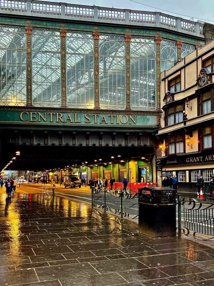This may contain: people are walking under an overpass on a rainy day