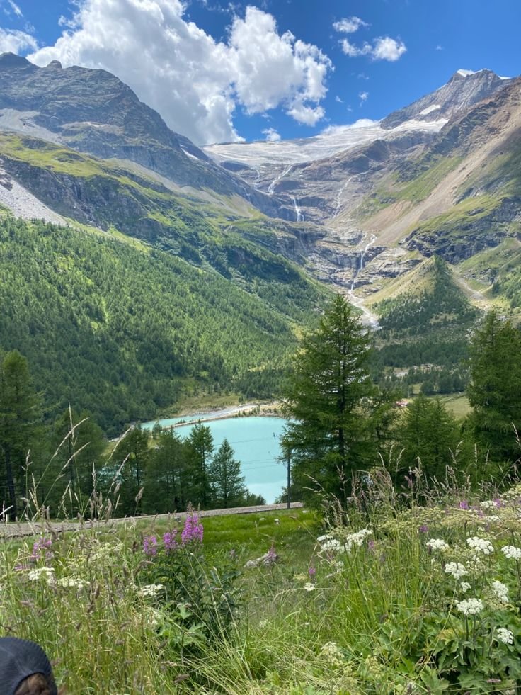 This may contain: there is a lake in the middle of mountains