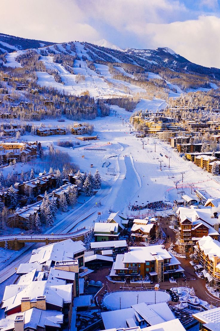 This may contain: an aerial view of a ski resort in the mountains with lots of snow on it