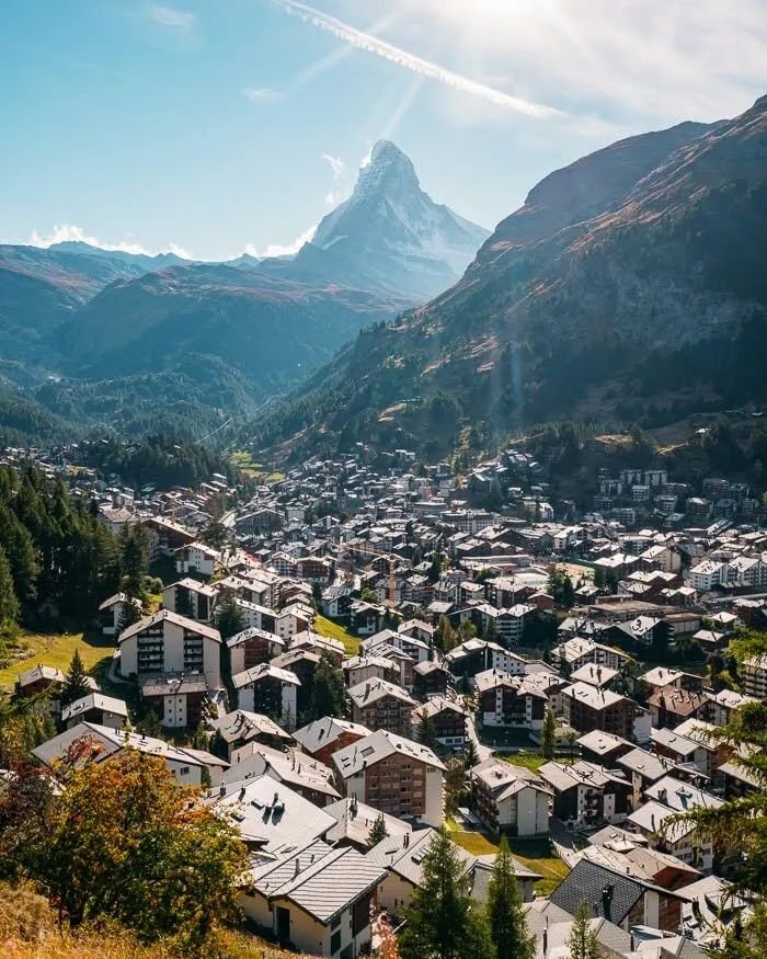 This may contain: an aerial view of a city with mountains in the background