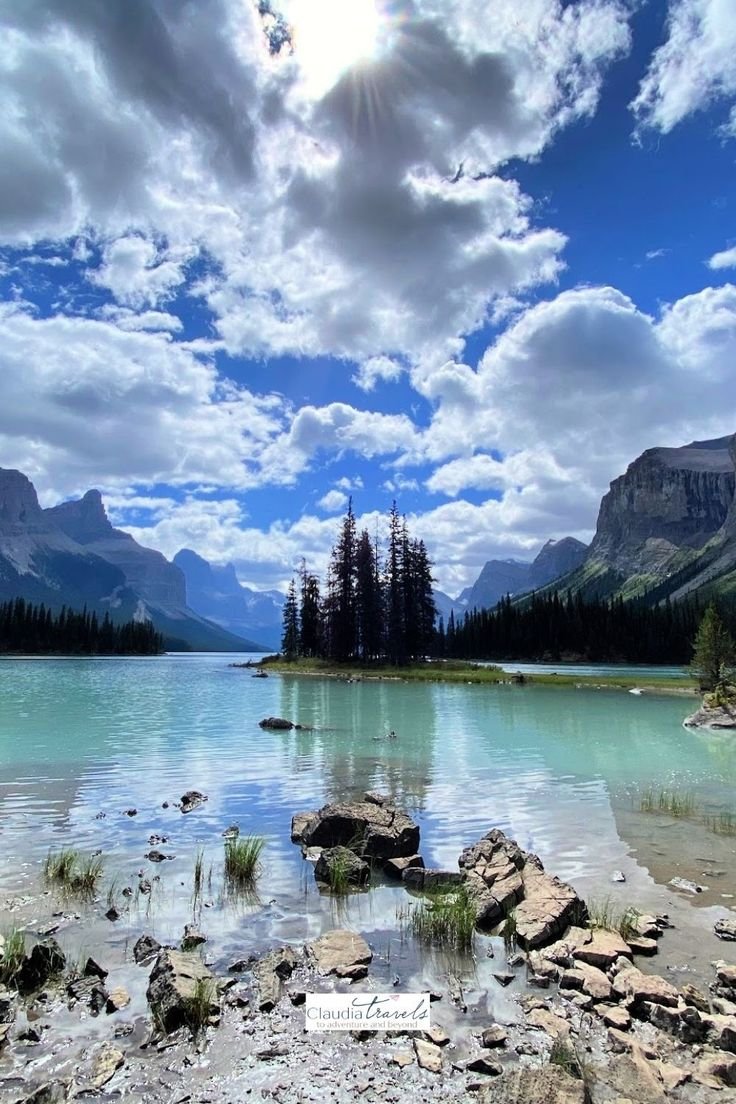 This may contain: the sun shines brightly over a mountain lake