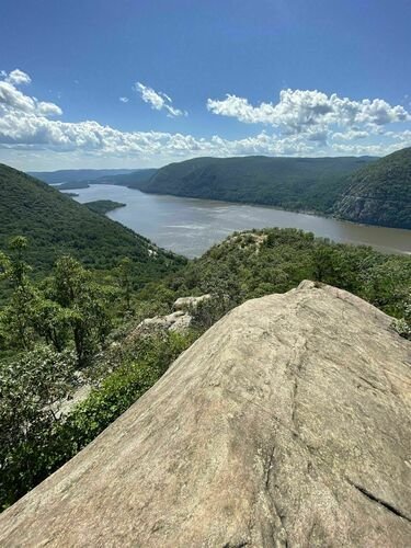 This may contain: a view from the top of a rock looking down at a lake