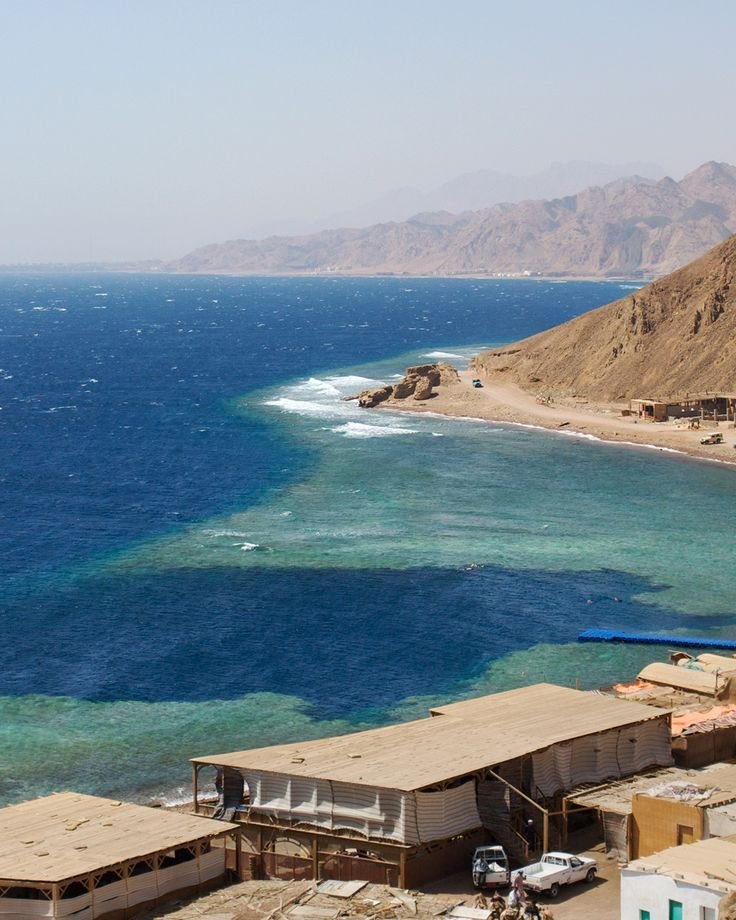 This may contain: the water is crystal blue and clear in this desert area, with houses on either side