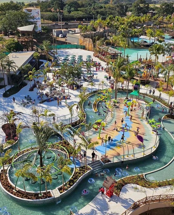 This may contain: an aerial view of a water park with many slides and waterslides surrounded by palm trees