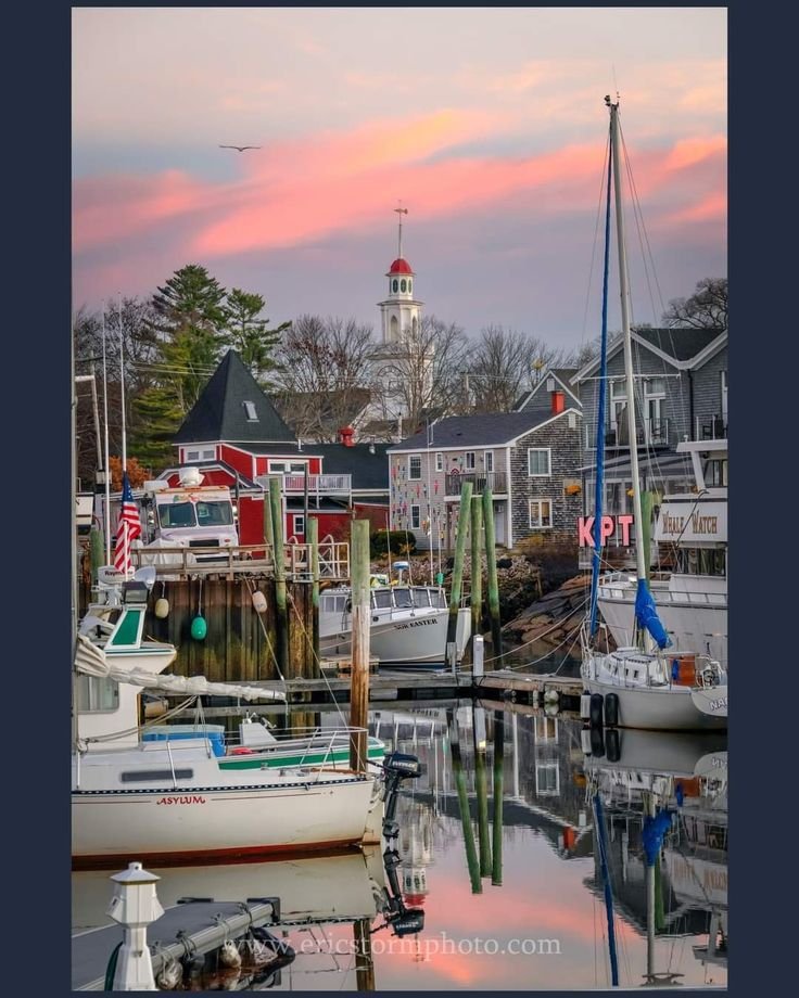 This may contain: many boats are docked in the harbor at sunset