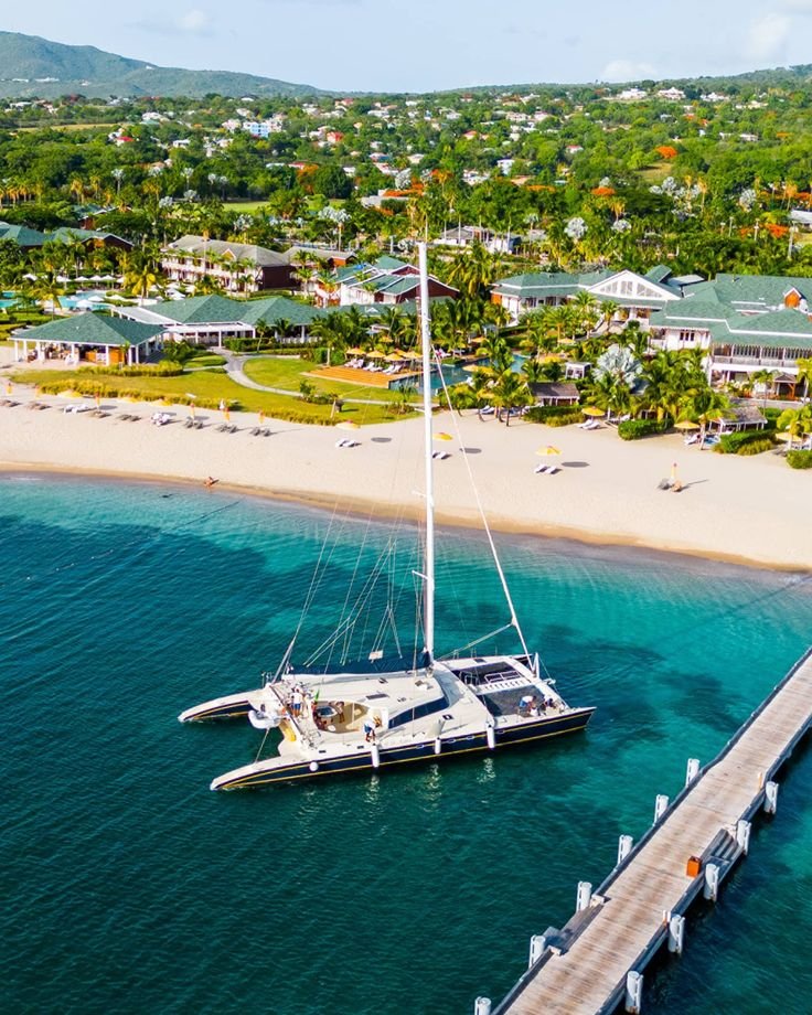 This may contain: an aerial view of a sailboat docked in the water next to a pier and houses