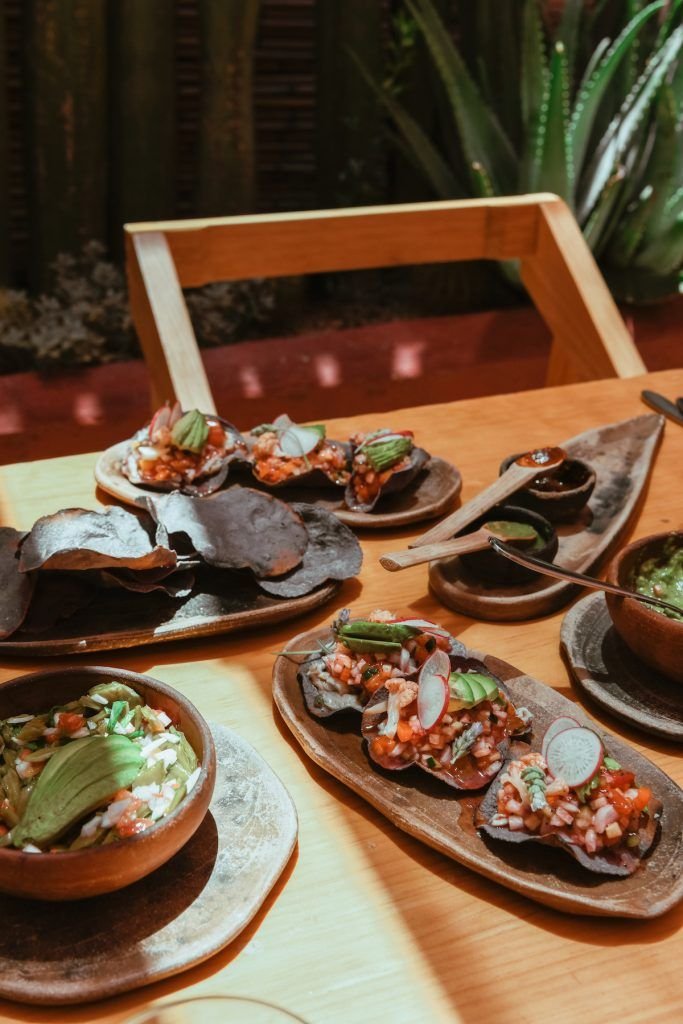 This may contain: a wooden table topped with plates filled with food